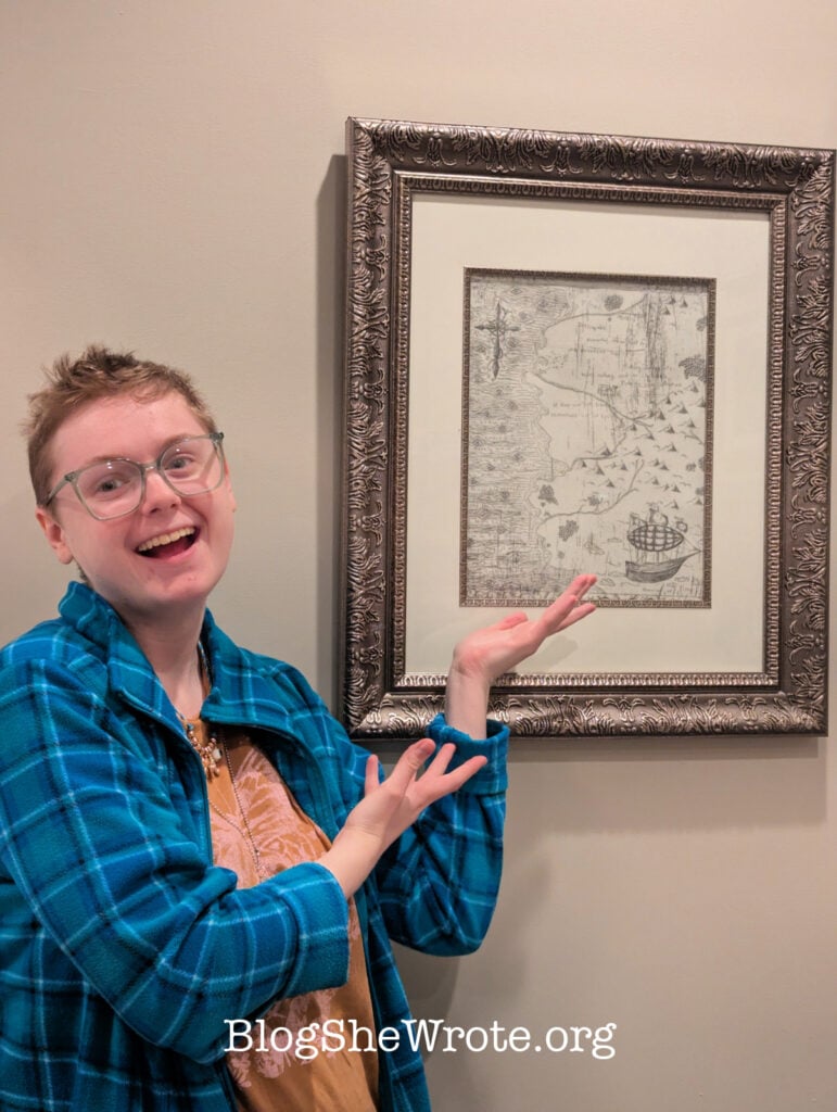 Young woman standing next to her own print of her own etched copper painting